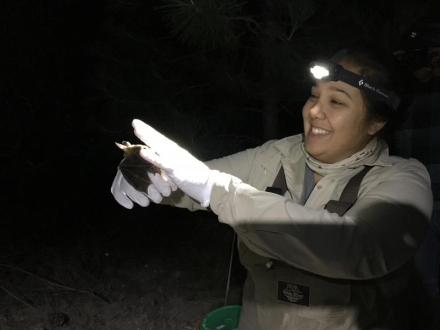 woman wearing a headlamp and holding a bat