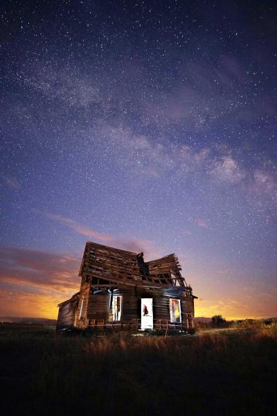 Night sky and dilapidated building with glow inside