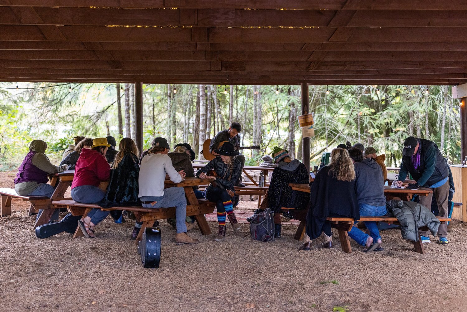 Group of songwriters at picnic benches in the woods