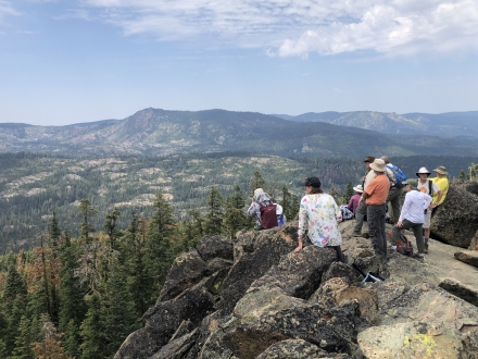 People on a mountain overlooking expansive view